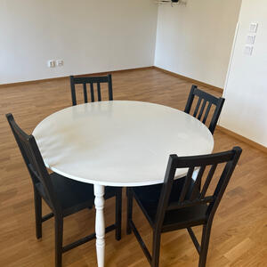 Runt vitt bord och fyra svarta stolar, råcksta